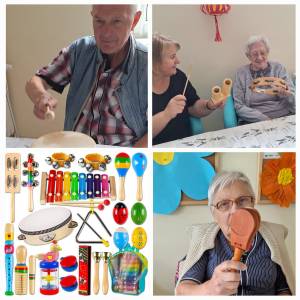 Seniorzy podczas zajęć muzycznych grają na prostych instrumentach perkusyjnych; widoczny także zestaw instrumentów zakupionych do terapii.